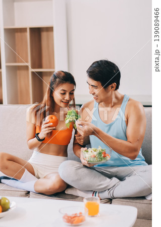 A happy couple prepares fresh vegetables, laughing and enjoying cooking a healthy meal together. A happy couple prepares fresh vegetables, laughing and enjoying cooking a healthy meal together. 139089466