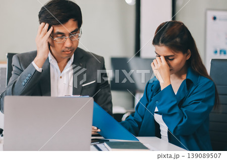 Millennial Asian stressed depressed worried thoughtful professional male businessman female businesswoman employee staff in formal business suit sitting thinking solving problem ideas in office room Millennial Asian stressed depressed worried thoughtful professional male businessman female businesswoman employee staff in formal business suit sitting thinking solving problem ideas in office room 139089507
