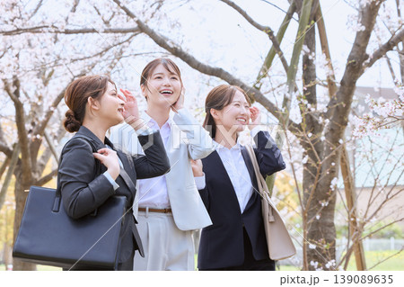 桜並木の下を歩く新入社員の若い女性3人・春のフレッシャーズイメージ・スーツ姿のビジネスウーマン 桜並木の下を歩く新入社員の若い女性3人・春のフレッシャーズイメージ・スーツ姿のビジネスウーマン 139089635