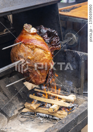 Roasting pork knuckle on a spit over open fire in Prague Roasting pork knuckle on a spit over open fire in Prague 139089960