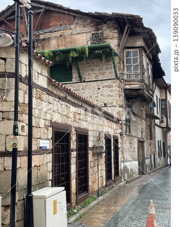 Old stone building on narrow cobblestone street reflecting historical architecture 139090033