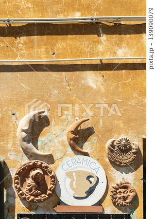 Artisan ceramics hanging on an old wall in Italy Artisan ceramics hanging on an old wall in Italy 139090079