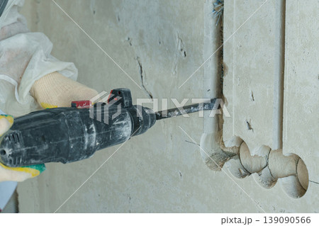 Electrician skillfully chasing electrical wiring during construction work 139090566