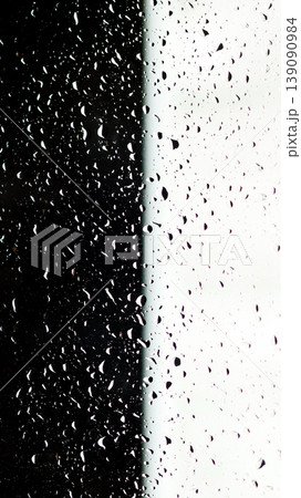 Minimalist texture of water drops on a glass surface. Rain on a clear window split into black and white sections creating a strong visual contrast 139090984