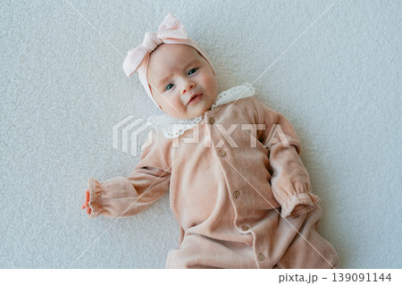 Close-up of baby girl looking at camera. Soft light and natural expression create an emotional portrait. Close-up of baby girl looking at camera. Soft light and natural expression create an emotional portrait. 139091144