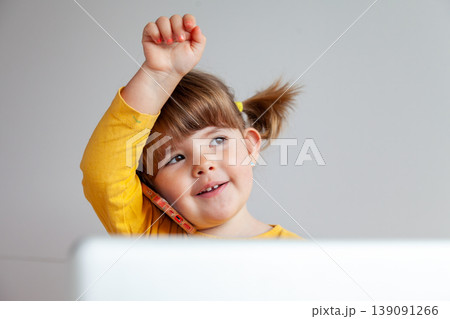 Three year old girl in yellow talking on a smartphone, concept of internet safety Three year old girl in yellow talking on a smartphone, concept of internet safety 139091266