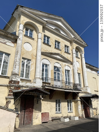 Historical building facade with classical columns under clear blue sky, ideal as architectural background 139092037