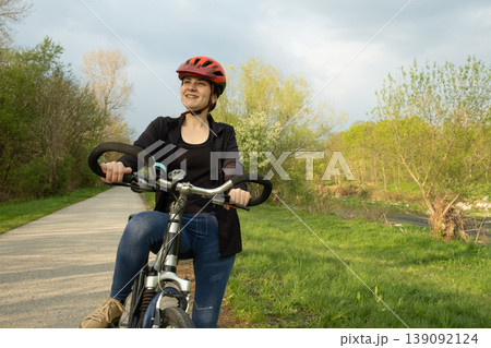 Fitness and recreation, young woman enjoying a bicycle ride in the spring park 139092124