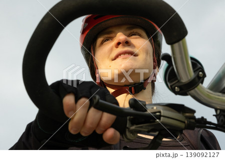 Woman cyclist holding handlebars against the sky, active lifestyle concept 139092127