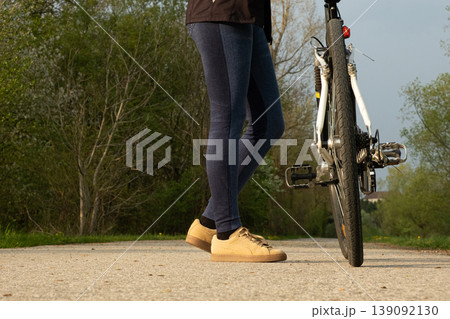 Low angle shot of cyclists legs standing next to a bicycle Low angle shot of cyclists legs standing next to a bicycle 139092130