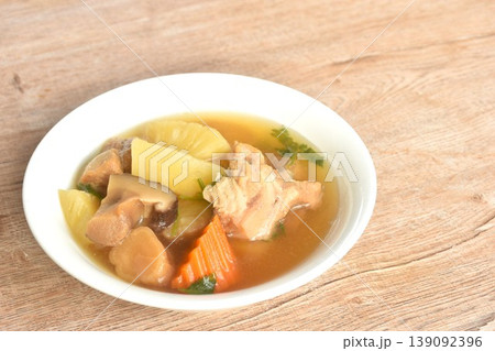 boiled pineapple with pork bone and carrot couple pickled radish topping black mushroom soup on bowl  139092396