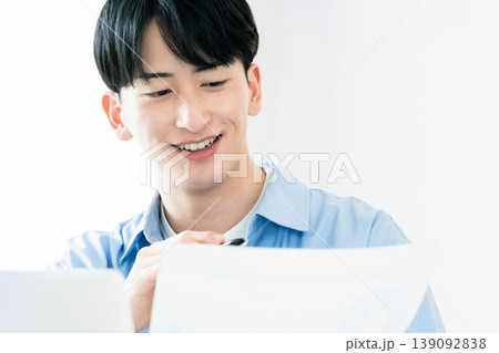資料を見ながら考える若い男性 資料を見ながら考える若い男性 139092838