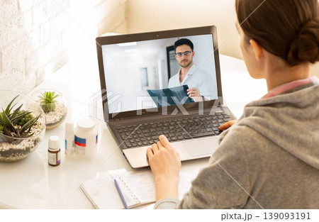 Woman sitting at home during an online consultation with her general practitioner. Medical technology, video chat with a doctor 139093191