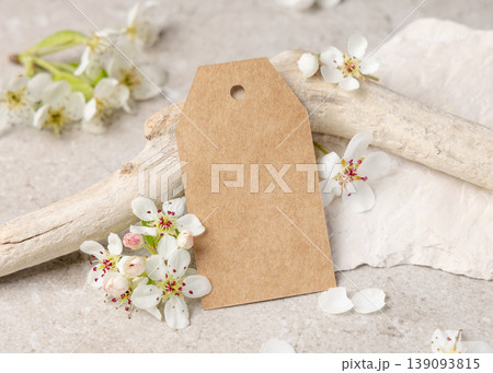 Blank vertical gift tag mockup with white spring flowers and driftwood on light stone, label design Blank vertical gift tag mockup with white spring flowers and driftwood on light stone, label design 139093815