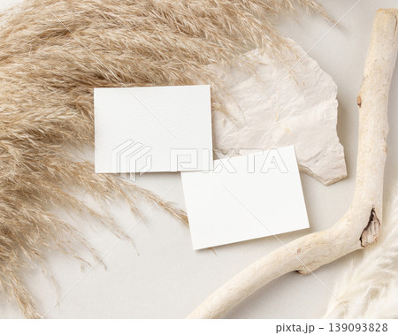Blank sided cards set mockup on beige stone with driftwood and pampas grass top view, wedding stationery 139093828