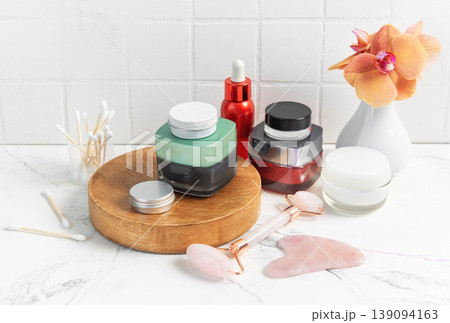 Skincare product bottles with jade roller and orchid Skincare product bottles with jade roller and orchid 139094163