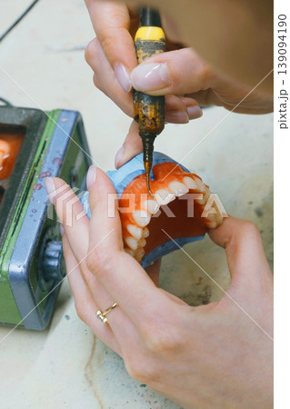 Crafting custom dentures with precision and skill in dental workshop Crafting custom dentures with precision and skill in dental workshop 139094190