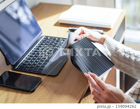 Designer choosing material swatches at home office workspace Designer choosing material swatches at home office workspace 139094262