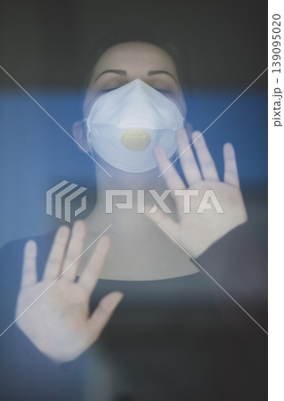 A woman staying at home in quarantine and watching the outside world through the window A woman staying at home in quarantine and watching the outside world through the window 139095020