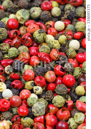 Top view of a mix of red, green, black, gray and white peppercorns. 139095373