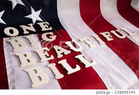 One Big Beautiful Bill wooden letter tiles arranged on American flag surface USA federal legislation concept One Big Beautiful Bill wooden letter tiles arranged on American flag surface USA federal legislation concept 139095545