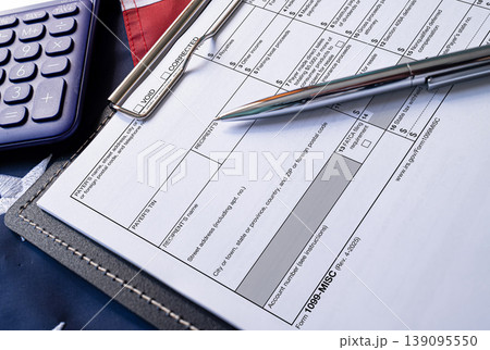 Tax form 1099-MISC with calculator and pen on clipboard Tax form 1099-MISC with calculator and pen on clipboard 139095550