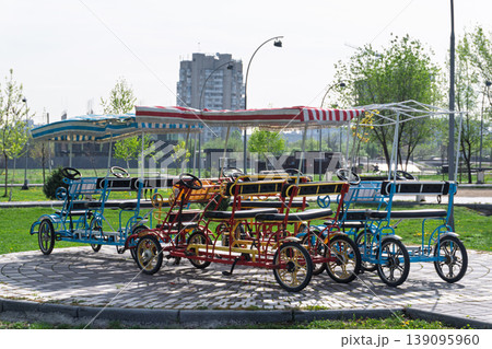 Empty passenger pedal cars parked in a city park Empty passenger pedal cars parked in a city park 139095960