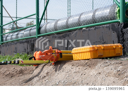 Surveying equipment lying on dirt at a construction site 139095961