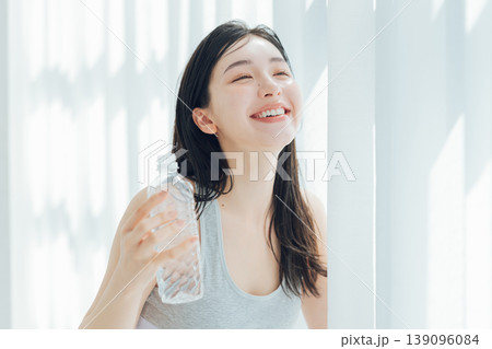 窓辺で水を飲む女性 139096084
