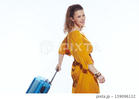 Happy Traveler Looking Back While Pulling Blue Luggage Happy Traveler Looking Back While Pulling Blue Luggage 139096112