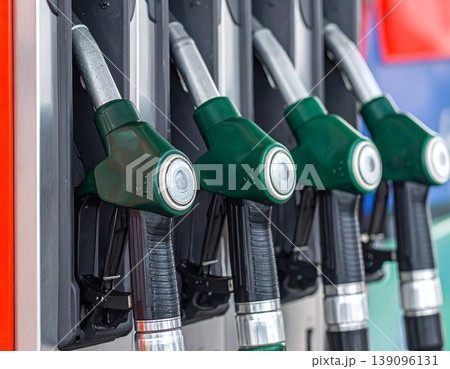 Fuel nozzles line up in a petrol station dispenser Fuel nozzles line up in a petrol station dispenser 139096131