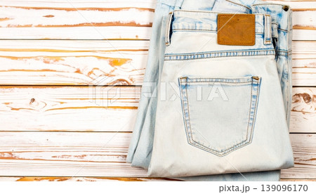 Folded blue jeans with a leather patch on a wooden background 139096170
