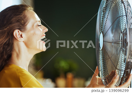 Woman Laughing with Electric Fan for Cooling 139096299