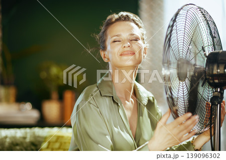 Close-up of Woman Enjoying Cool Air from Fan 139096302