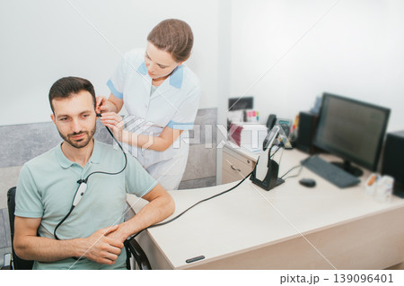 Mixed race man having a hearing test with special medical equipment. Impedance audiometry, tympanometry in a hearing center Mixed race man having a hearing test with special medical equipment. Impedance audiometry, tympanometry in a hearing center 139096401