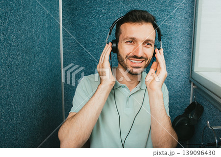 Audiometer hearing exam. Mixed race man wearing special headphones getting a hearing test at the special audio room Audiometer hearing exam. Mixed race man wearing special headphones getting a hearing test at the special audio room 139096430
