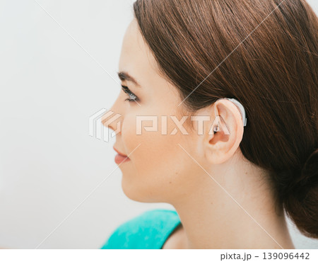 BTE hearing aid on female ear. Deafness treatment, hearing solution BTE hearing aid on female ear. Deafness treatment, hearing solution 139096442