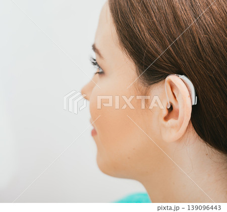 BTE hearing aid on female ear. Deafness treatment, hearing solution BTE hearing aid on female ear. Deafness treatment, hearing solution 139096443