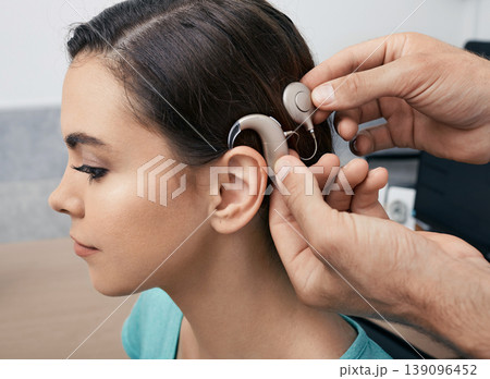 Cochlear implant. Installation cochlear implant on woman's ear for restores hearing Cochlear implant. Installation cochlear implant on woman's ear for restores hearing 139096452