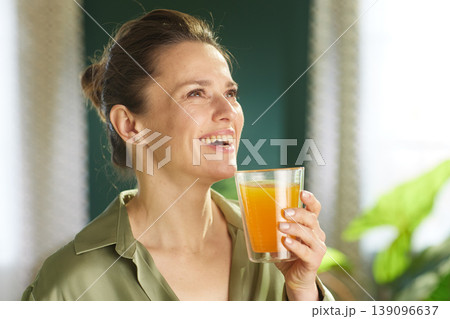 Woman Smiling with a Glass of Fresh Morning Juice Woman Smiling with a Glass of Fresh Morning Juice 139096637