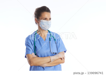 Pensive Healthcare Worker in Blue Scrubs and Safety Mask Pensive Healthcare Worker in Blue Scrubs and Safety Mask 139096741