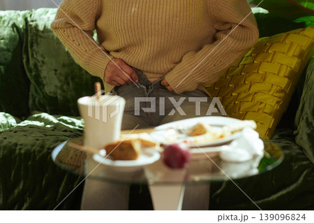 Woman Struggling with Tight Jeans After Overeating 139096824