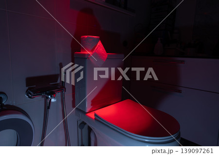 Toilet bowl with toilet paper roll in bathroom. Illumination for bowel movement problem concept. Toilet bowl with toilet paper roll in bathroom. Illumination for bowel movement problem concept. 139097261