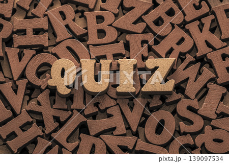 Inscription quiz on pile of old vintage wooden letters. Inscription quiz on pile of old vintage wooden letters. 139097534