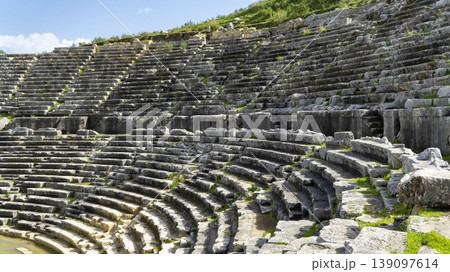 Ancient stone seating of the Hellenistic theater at Letoon ancient city, showing curved rows, weathered textures and terraced structure near city of Xanthos, Mugla, Turkey Ancient stone seating of the Hellenistic theater at Letoon ancient city, showing curved rows, weathered textures and terraced structure near city of Xanthos, Mugla, Turkey 139097614