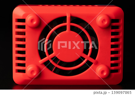 Red cooling fan on a black surface in a simple setup Red cooling fan on a black surface in a simple setup 139097865
