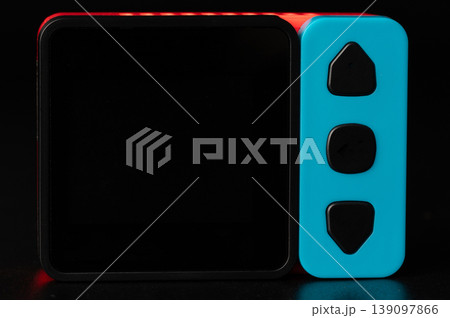 Red and blue device with side buttons on a dark background Red and blue device with side buttons on a dark background 139097866