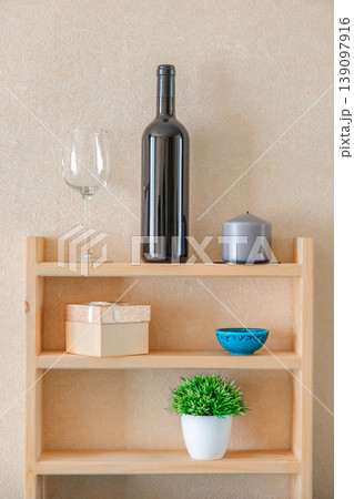 bottle of wine, candle and dishes on wooden shelves 139097916