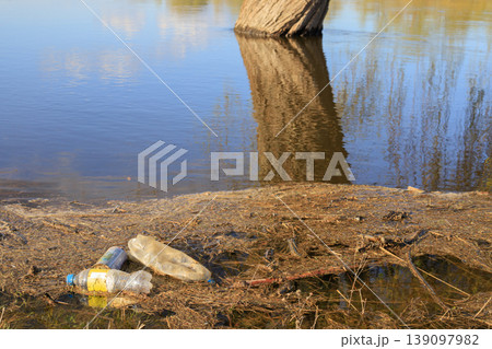 Plastic bottles discarded in shallow water among grass. Concept of environmental and water pollution. Litter impacting nature, aquatic ecosystems Plastic bottles discarded in shallow water among grass. Concept of environmental and water pollution. Litter impacting nature, aquatic ecosystems 139097982