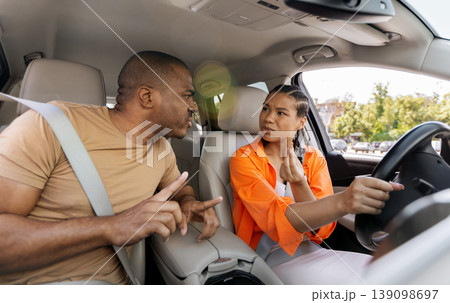 Young African American couple arguing in car, man pointing and woman reacting Young African American couple arguing in car, man pointing and woman reacting 139098697